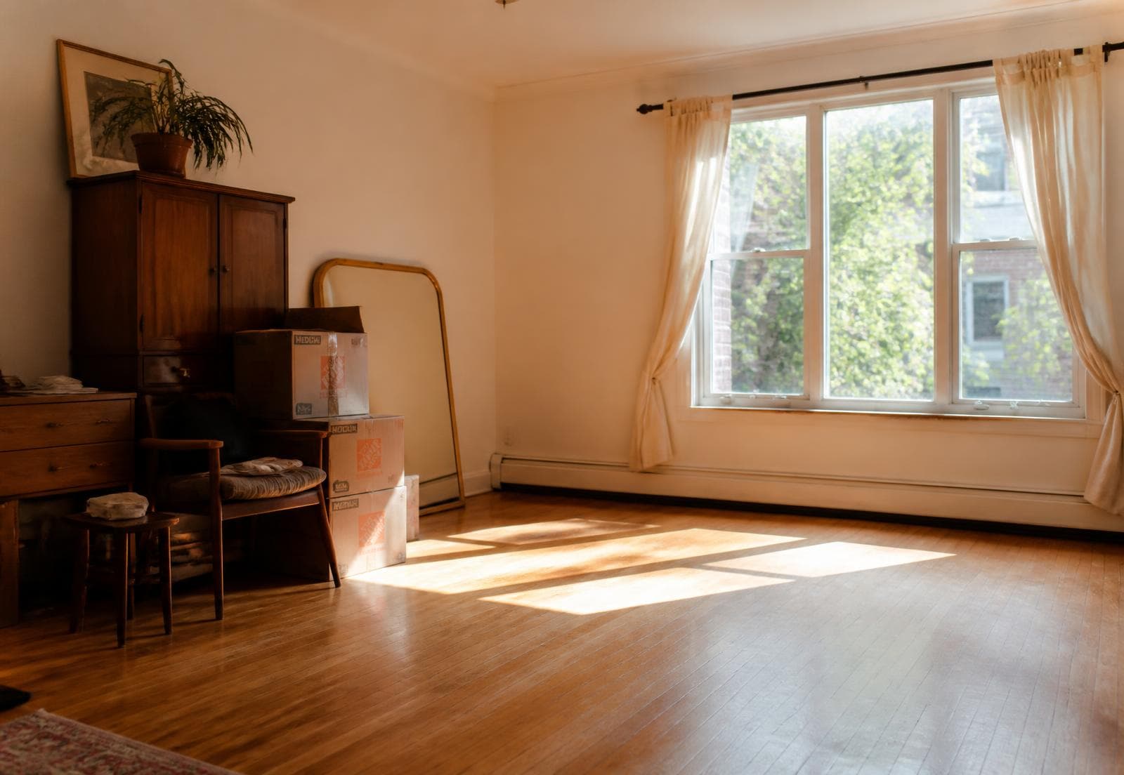 Habitación a medio vaciar con luz entrando por la ventana